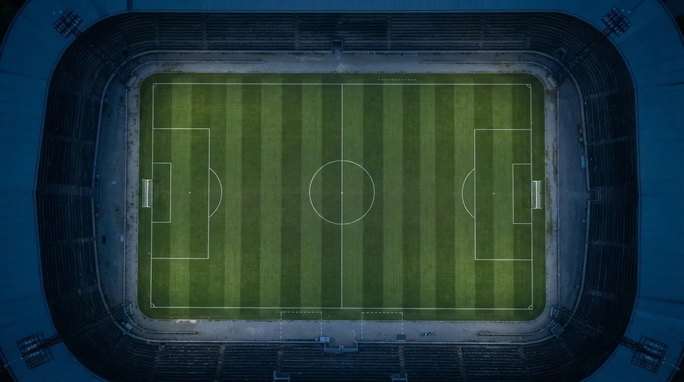 Ein Fußballplatz am Abend aus der Vogelperspektive, Flutlichtmasten ausgeschaltet, die Rasenlinien deutlich sichtbar.